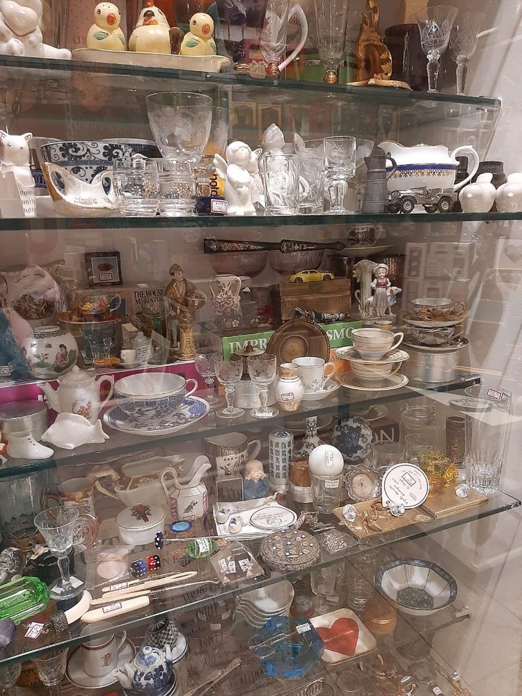 Glass shelves of a store. Full of small varied items, mostly made of glass and porcelain.